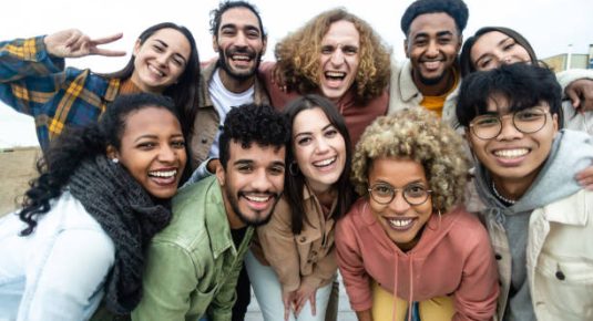 Happy group of multiethnic young friends - Diverse people smiling at camera outdoors - Community and unity people concept