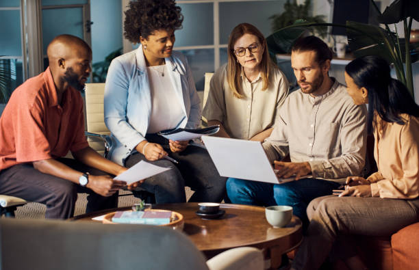 programme groupe Group of five diverse businesspeople talking having a meeting using a laptop together at work
